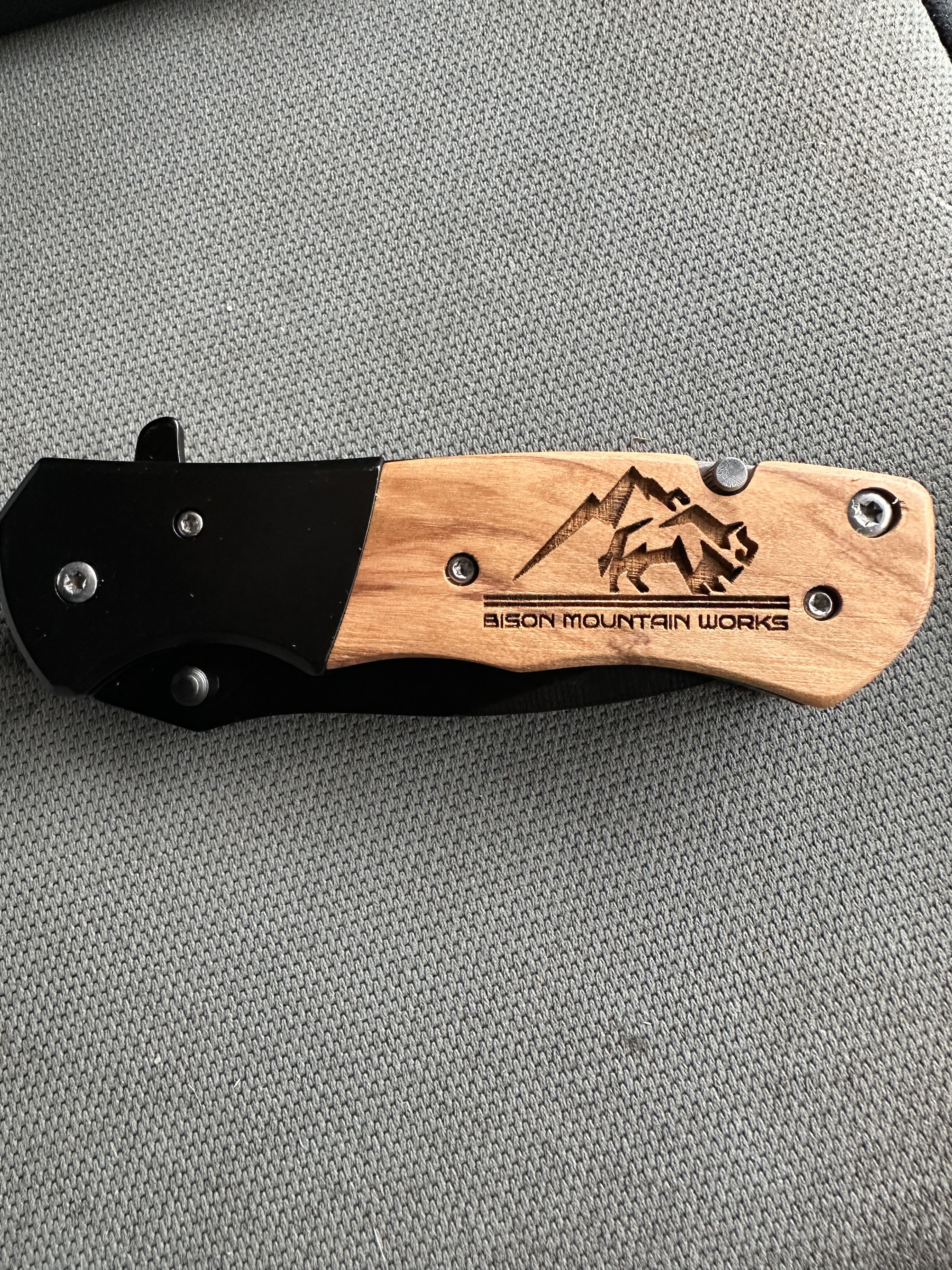 Laser-engraved personalized knife with custom name and design on a wooden surface